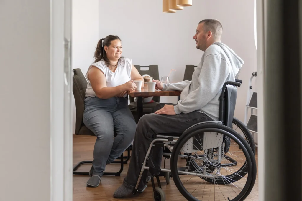 Support worker chatting with disabled man in wheelchair